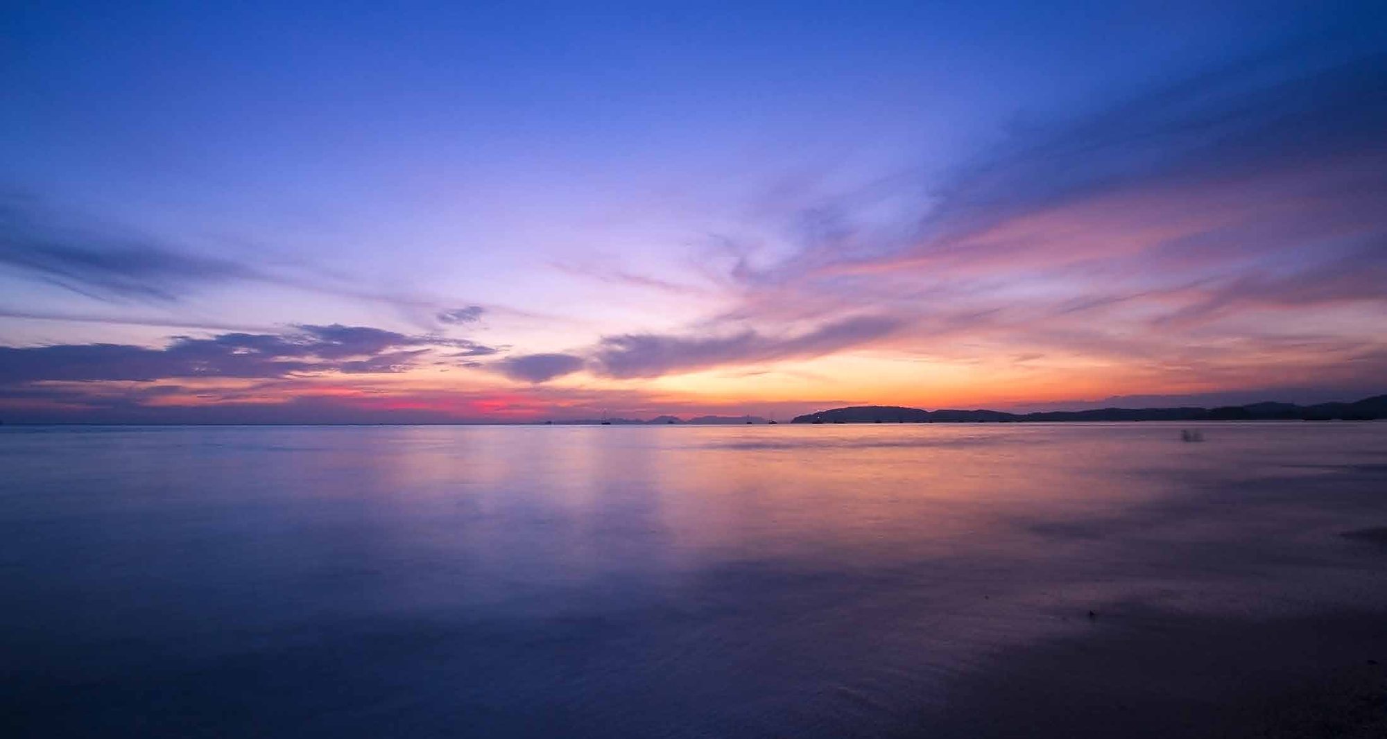 Sunset over the water beside a DAMAC waterfront community